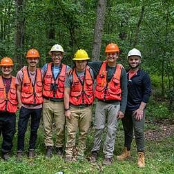 A team of W&由生物学教授Jason Kilgore博士带领的J学生.D. 在宾夕法尼亚州西北部的阿勒格尼国家森林工作，监测受翠绿灰螟(EAB)影响的白蜡树的健康状况。, 这是一种来自亚洲的入侵昆虫，已经杀死了美国和加拿大各地数亿棵白蜡树. 创意总监Matt Michalko和平面设计师Cameron Haid在花了2天时间记录他们的工作后与工作人员合影.
